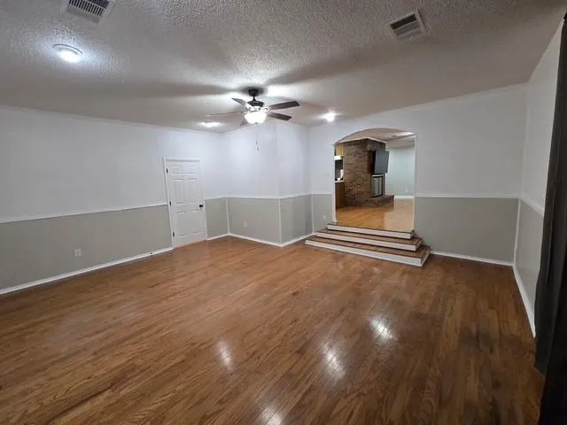 a view of a livingroom with a piano and wooden floor