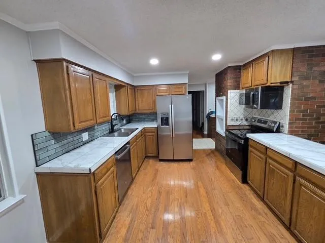 a kitchen with stainless steel appliances granite countertop a stove a sink dishwasher a refrigerator and a oven
