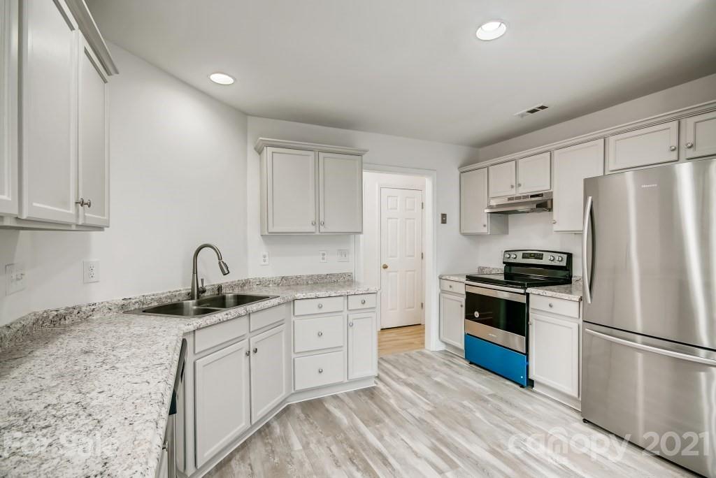 1512 Mineral Springs Road Charlotte, NC 28262 - Photo 7 of 19 a kitchen with a sink white cabinets and stainless steel appliances