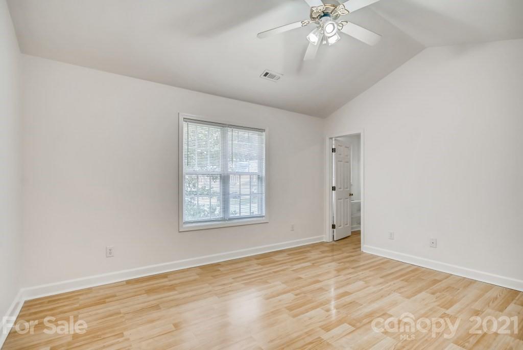 1512 Mineral Springs Road Charlotte, NC 28262 - Photo 10 of 19 an empty room with chandelier fan and windows