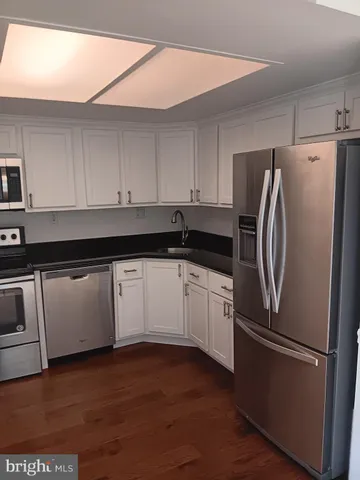 a kitchen with a refrigerator and white cabinets
