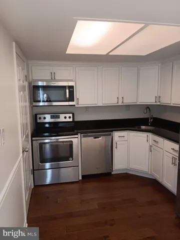 a kitchen with appliances a sink and cabinets