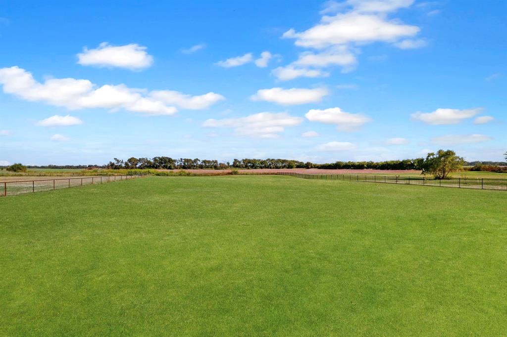 634 Gant Road Sherman, TX 75090 - Photo 32 of 40 Expansive open field with green grass, perimeter fencing, and distant tree line