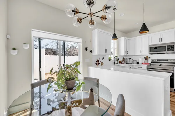 a kitchen with stainless steel appliances kitchen island refrigerator cabinets and a chandelier