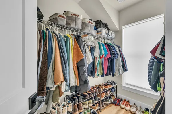 a view of walk in closet with clothes and shoes