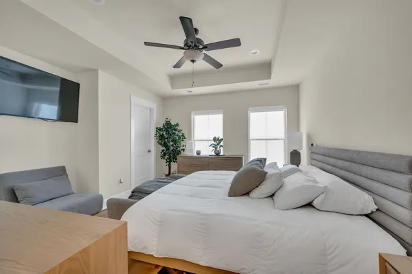 a bedroom with a large bed and a chandelier