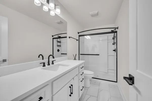a bathroom with a sink a mirror a vanity and shower