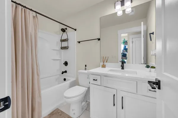 a bathroom with a sink a toilet a mirror and shower