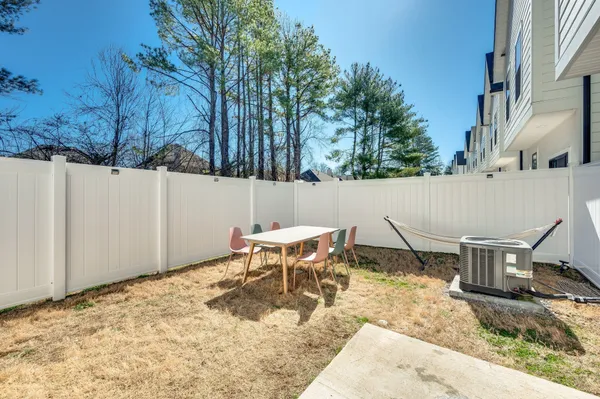 a backyard of a house with table and chairs