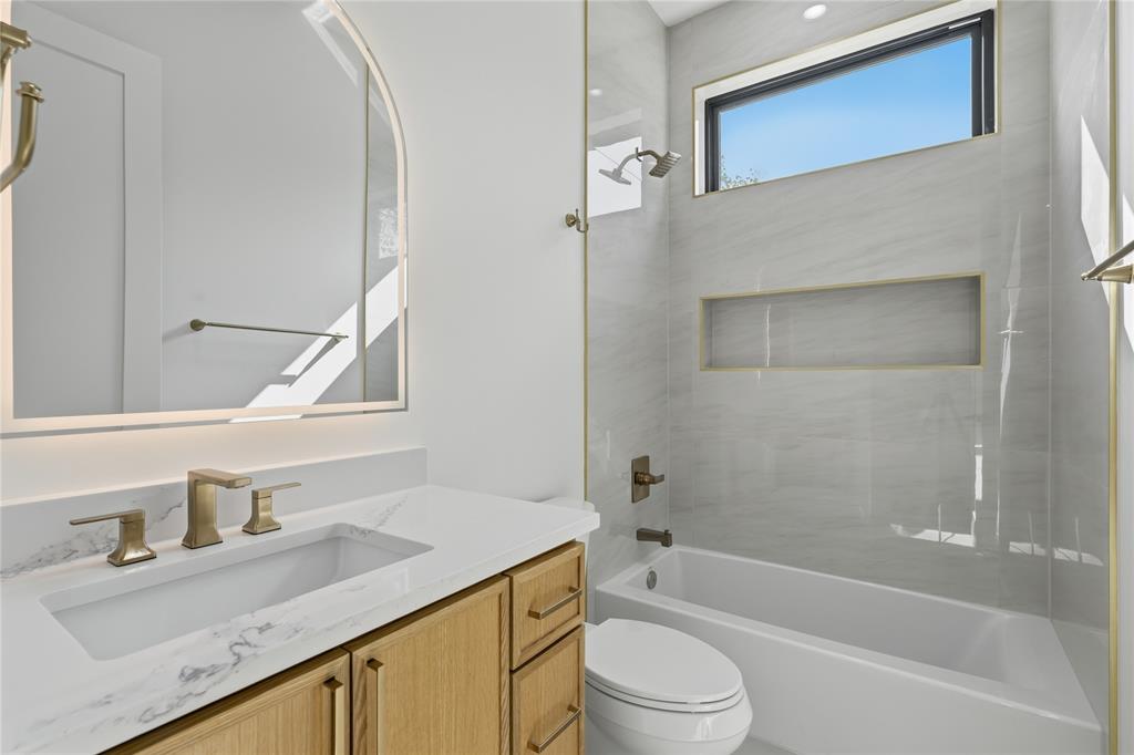 6038 Prospect Avenue Dallas, TX 75206 - Photo 26 of 40 Bathroom featuring a light wood vanity with a white countertop, an undermount sink, and brass fixtures