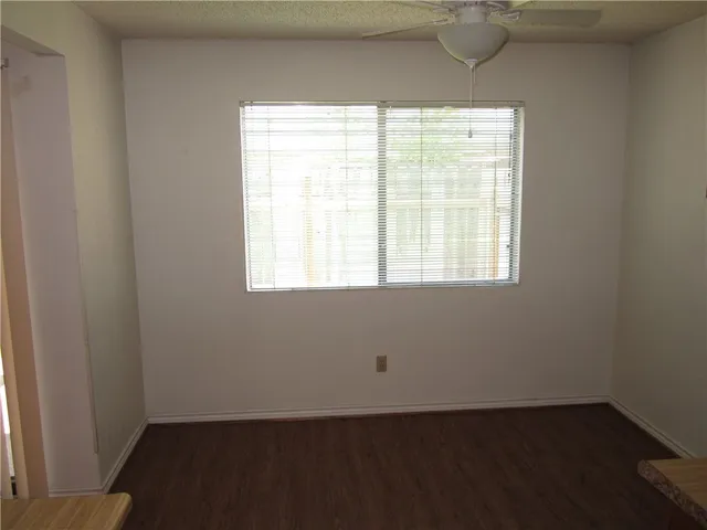 an empty room with wooden floor and a window