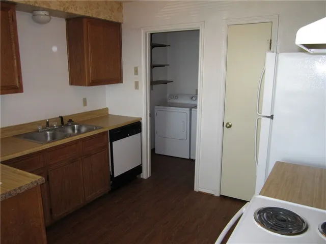 a kitchen with a sink and a stove with wooden floor