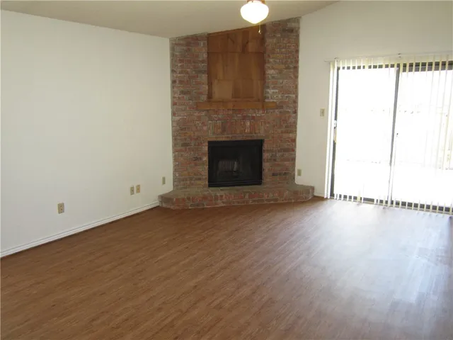 a view of a room with wooden floor and a fireplace