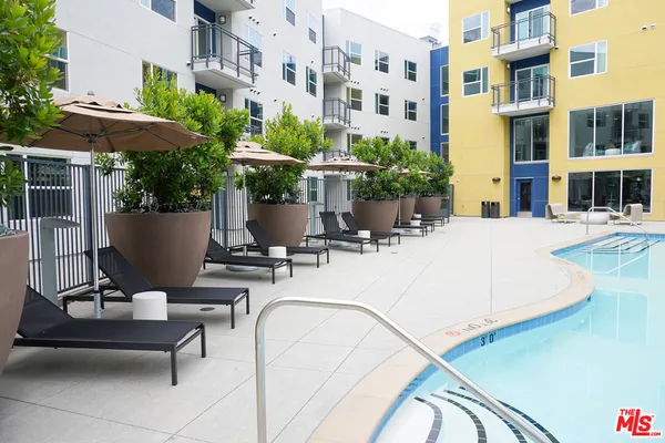 a view of a patio with couches table and chairs under an umbrella