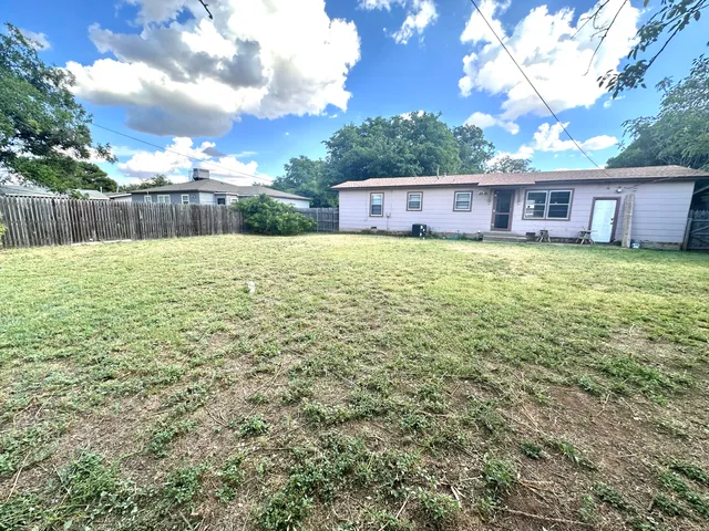 a large tree with wooden fence