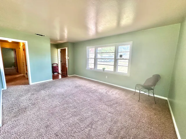 a furnished livingroom with windows and bathroom