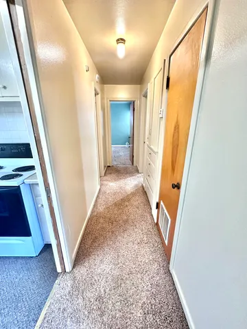 view of a hallway with wooden floor and stairs