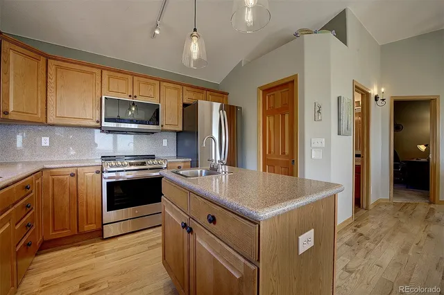 a kitchen with kitchen island granite countertop a sink stove and refrigerator