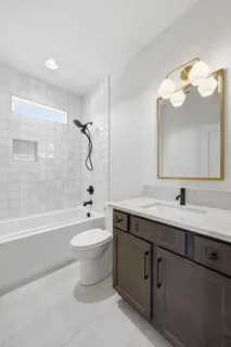 a bathroom with a bathtub shower sink mirror and toilet