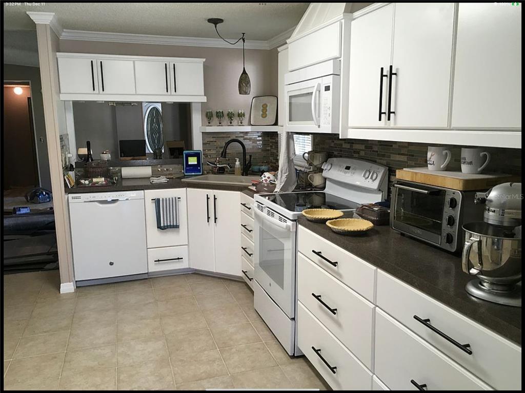 90 Whipporwill Court Ellenton, FL 34222 - Photo 13 of 34 a kitchen with stainless steel appliances granite countertop white cabinets a sink and dishwasher