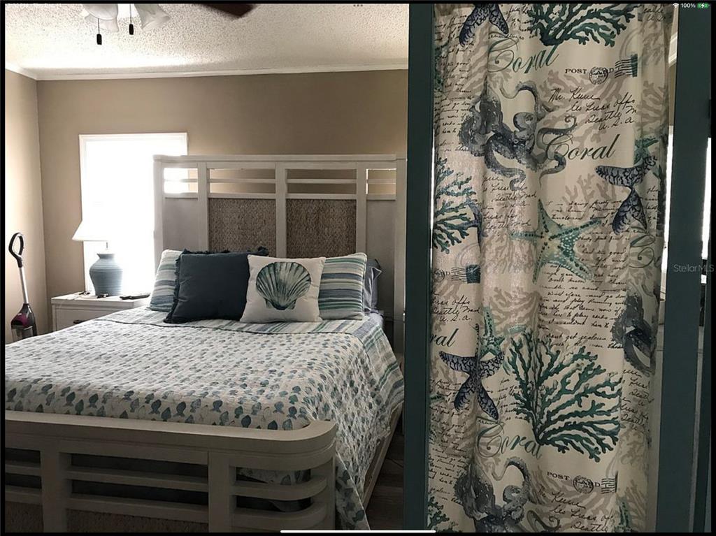 90 Whipporwill Court Ellenton, FL 34222 - Photo 14 of 34 a large bed sitting in a bedroom next to a bathroom sink with wooden floor