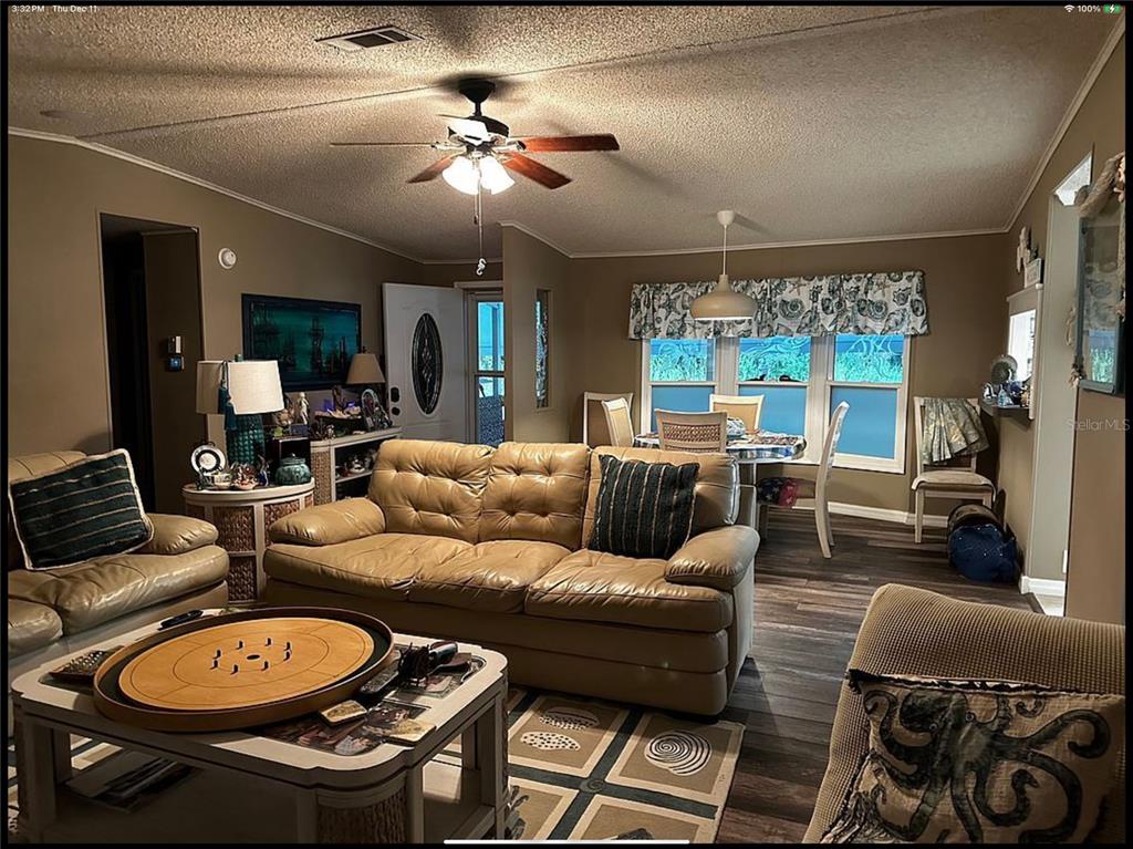 90 Whipporwill Court Ellenton, FL 34222 - Photo 10 of 34 a living room with furniture a large window and a chandelier