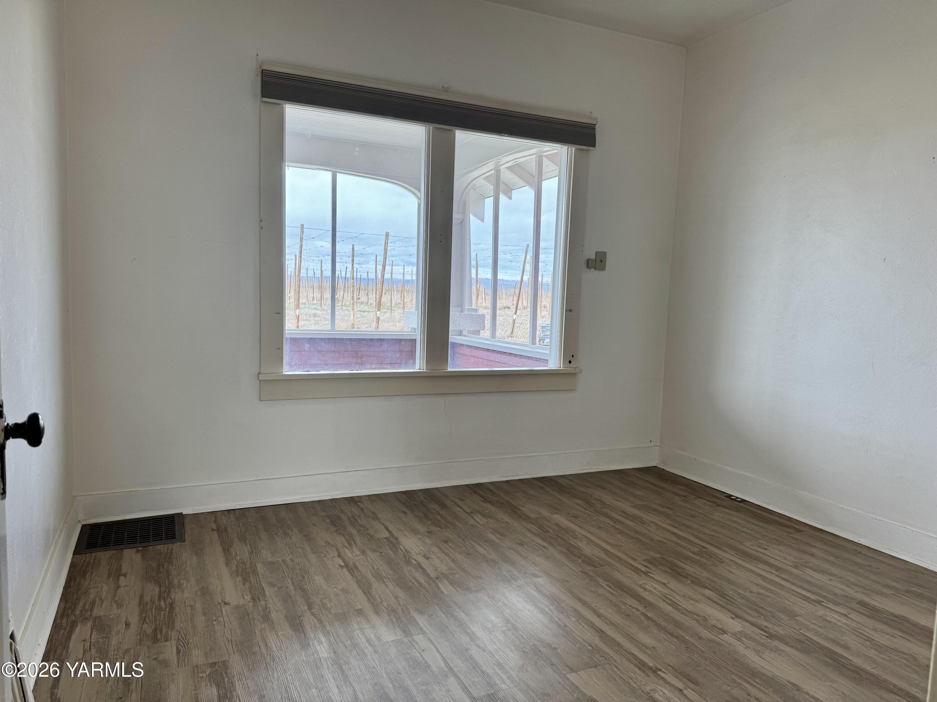 7801 Campbell Road, Unit 1 Toppenish, WA 98948 - Photo 25 of 46 an empty room with wooden floor and windows