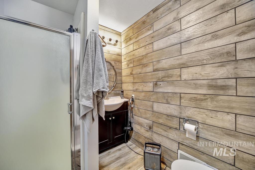 111 2nd Street Rupert, ID 83350 - Photo 27 of 45 Bathroom featuring wood-finish tile accent wall and coordinating wood-finish flooring