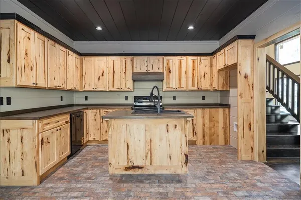 a kitchen with stainless steel appliances granite countertop a stove a sink and a refrigerator