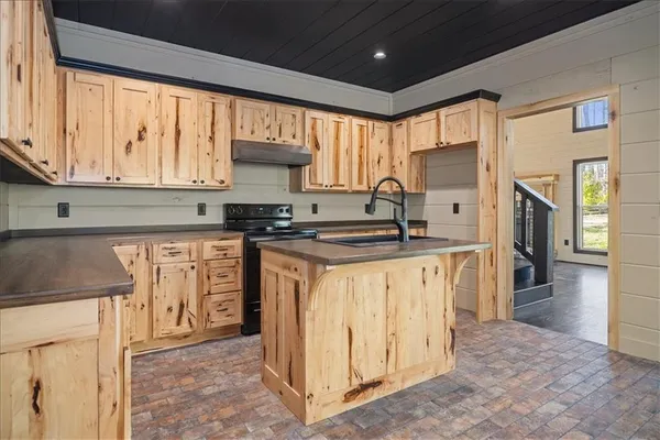 a kitchen with stainless steel appliances granite countertop a stove a sink and a refrigerator