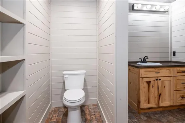 a bathroom with a granite countertop toilet and a sink