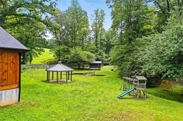 a view of house with backyard and a slide