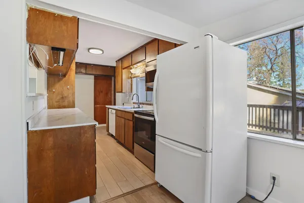 a kitchen with stainless steel appliances granite countertop a sink and wooden cabinets
