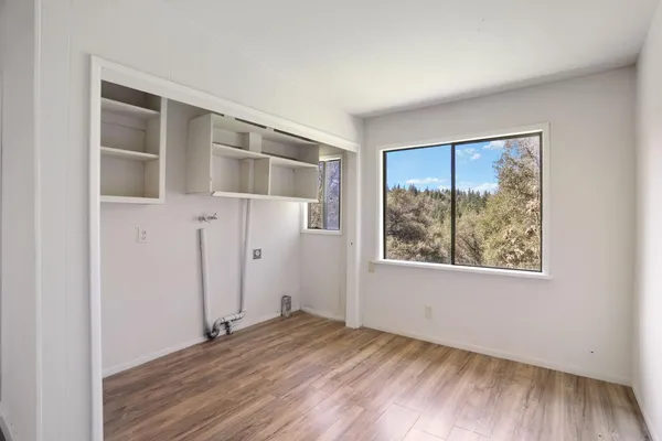 a view of empty room with wooden floor