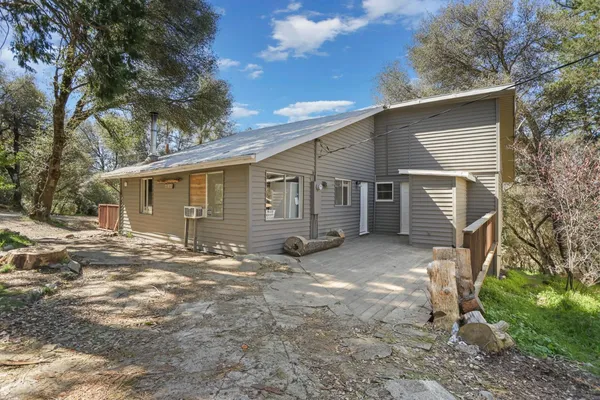 a view of a house with backyard and a tree