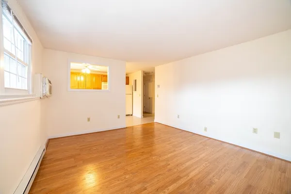 a view of empty room with a ceiling fan and wooden floor