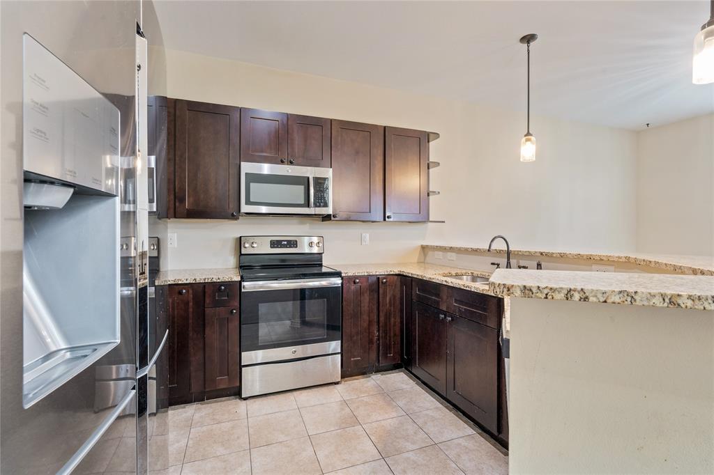 104 Eagle Meadow Drive Weatherford, TX 76087 - Photo 11 of 40 a kitchen with stainless steel appliances granite countertop a stove a sink and a microwave