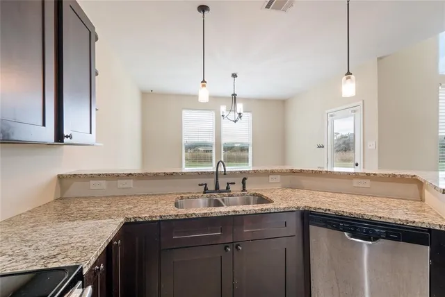 a kitchen with granite countertop cabinets sink and window