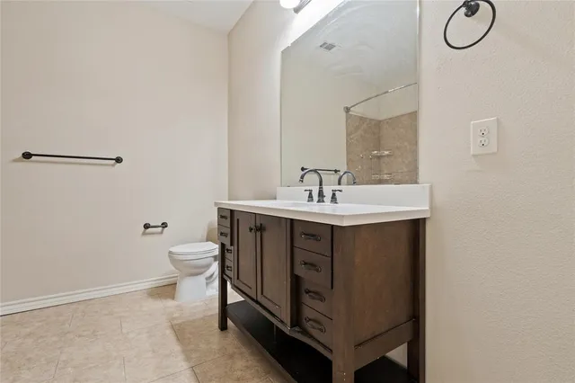 a bathroom with a sink vanity and toilet