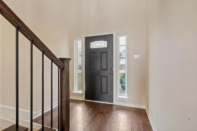a view of a hallway with wooden floor and stairs