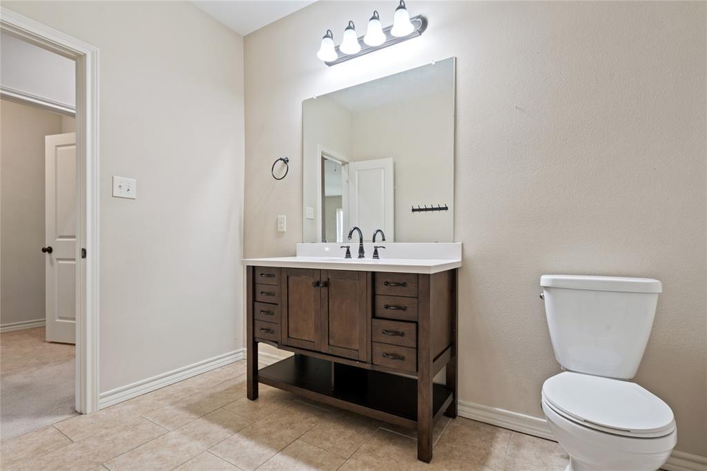 104 Eagle Meadow Drive Weatherford, TX 76087 - Photo 31 of 40 a bathroom with a toilet a sink and mirror