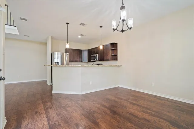 a view of a kitchen with a sink and dishwasher a refrigerator with wooden floor