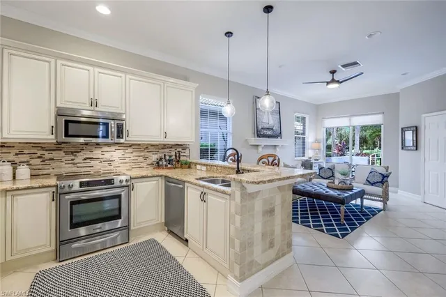 a kitchen with granite countertop a sink and white cabinets