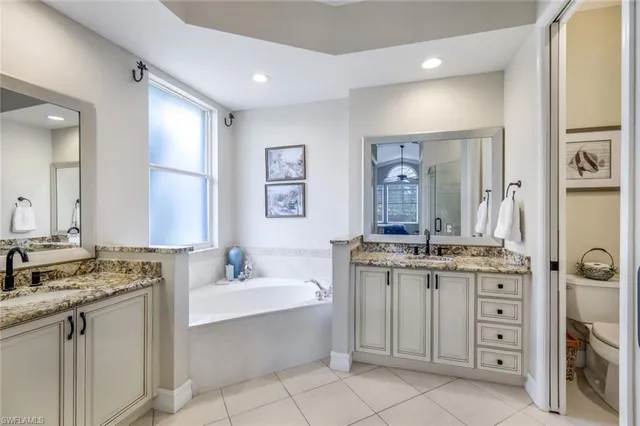 a bathroom with a granite countertop sink double vanity and a mirror