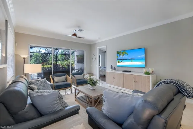 a living room with furniture a large window and a chandelier