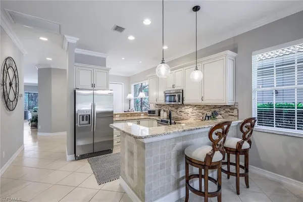 a kitchen with kitchen island granite countertop a stove a sink and a refrigerator