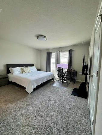 a spacious bedroom with a bed and a large window