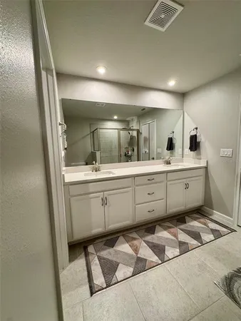 a bathroom with a double vanity sink and mirror