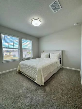 a bedroom with a bed and a large window