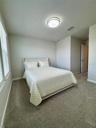 a bedroom with a bed and a large window